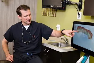 Dr. Cutting showing how dental implants can help restore a patient's smile